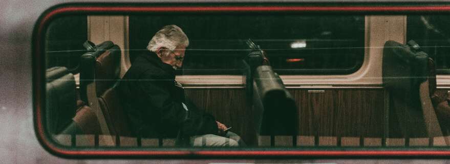 stresshormoon-cortisol man in de trein kijkend op een telefoon